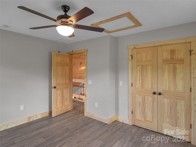unfurnished bedroom with wood finished floors, ceiling fan, baseboards, and a closet