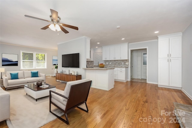 living room featuring ceiling fan, ornamental molding, and light hardwood / wood-style floors