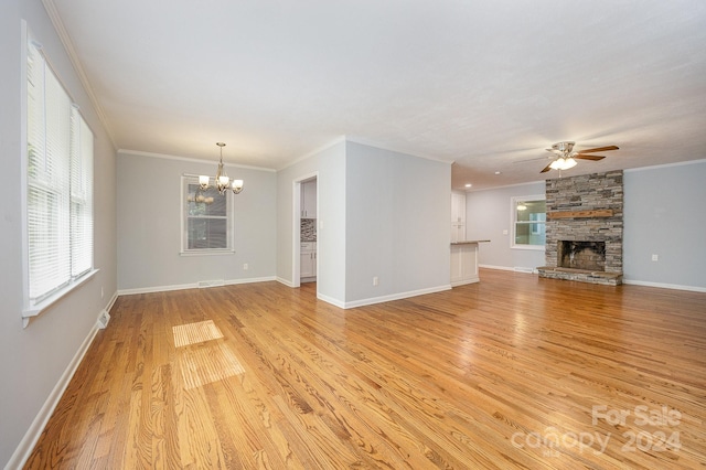 unfurnished living room with a fireplace, ornamental molding, ceiling fan with notable chandelier, and light wood-type flooring