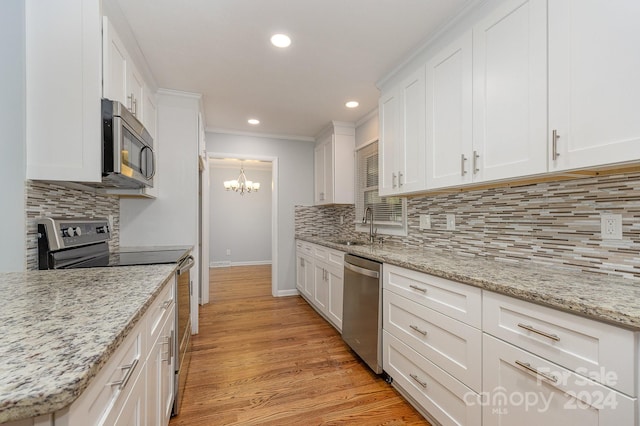 kitchen with white cabinetry, light hardwood / wood-style flooring, stainless steel appliances, and an inviting chandelier