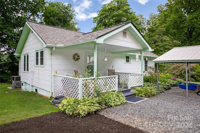 back of house featuring central AC unit, a carport, and a yard