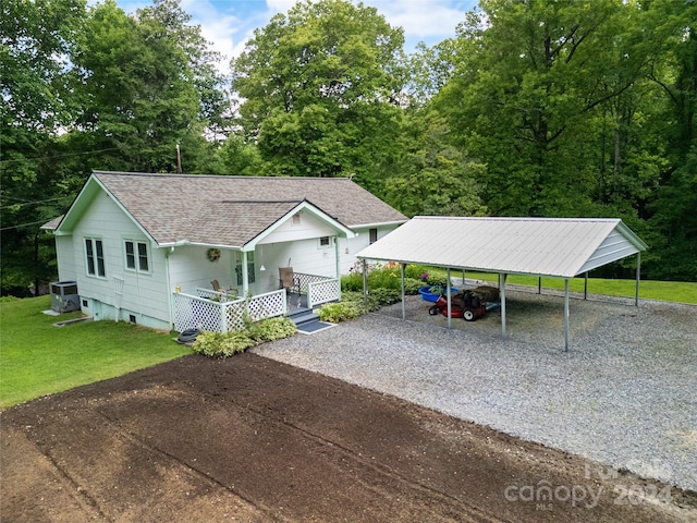 view of front facade with a front yard, central AC, and a carport