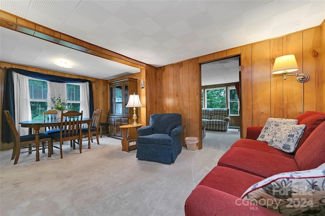 carpeted living room featuring wooden walls