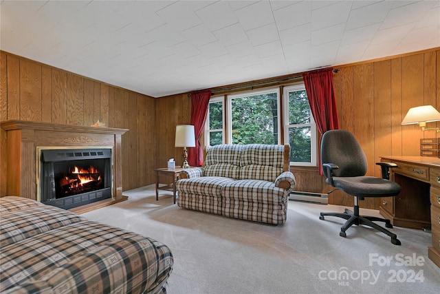 carpeted bedroom with a baseboard heating unit and wood walls