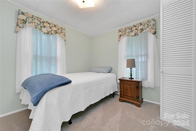 bedroom featuring light colored carpet and crown molding