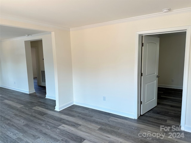 unfurnished room with baseboards, dark wood finished floors, visible vents, and crown molding