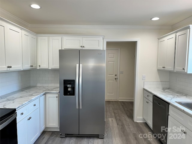 kitchen with decorative backsplash, appliances with stainless steel finishes, dark wood-type flooring, light stone countertops, and white cabinetry