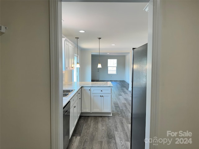 kitchen featuring a peninsula, dark wood-style flooring, white cabinets, stainless steel dishwasher, and decorative light fixtures