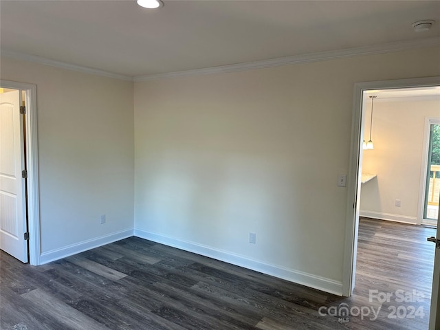 spare room featuring dark wood-style floors, baseboards, and crown molding