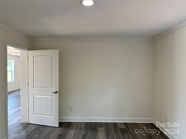 unfurnished room featuring baseboards, dark wood-style flooring, and ornamental molding