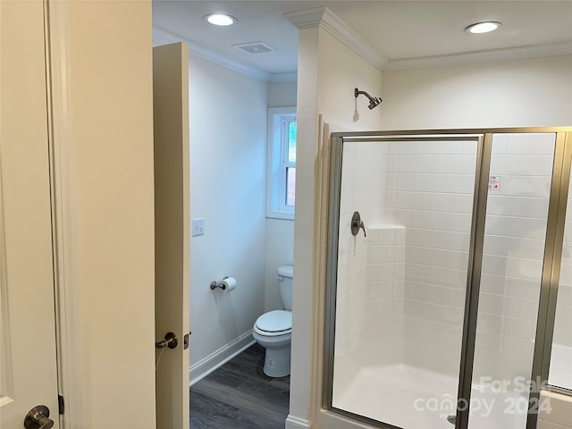 full bath with visible vents, toilet, wood finished floors, crown molding, and a shower stall