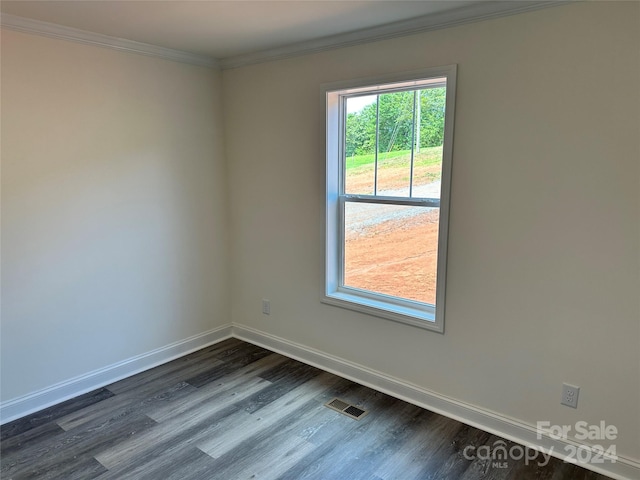 unfurnished room featuring dark wood-type flooring, visible vents, crown molding, and baseboards