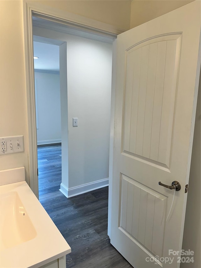 bathroom featuring vanity, baseboards, and wood finished floors