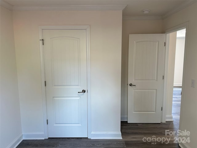 interior space featuring dark wood-style floors, ornamental molding, and baseboards