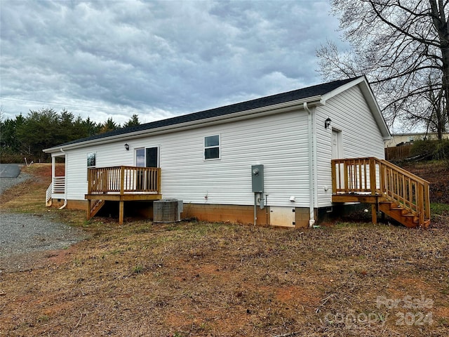 rear view of property with central air condition unit and crawl space