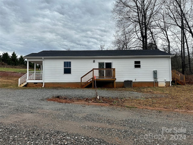 rear view of property featuring crawl space and central AC