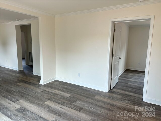 unfurnished room with dark hardwood / wood-style flooring and crown molding