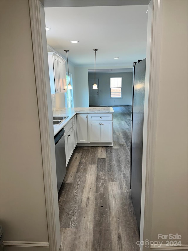 kitchen featuring kitchen peninsula, appliances with stainless steel finishes, decorative light fixtures, dark hardwood / wood-style flooring, and white cabinetry