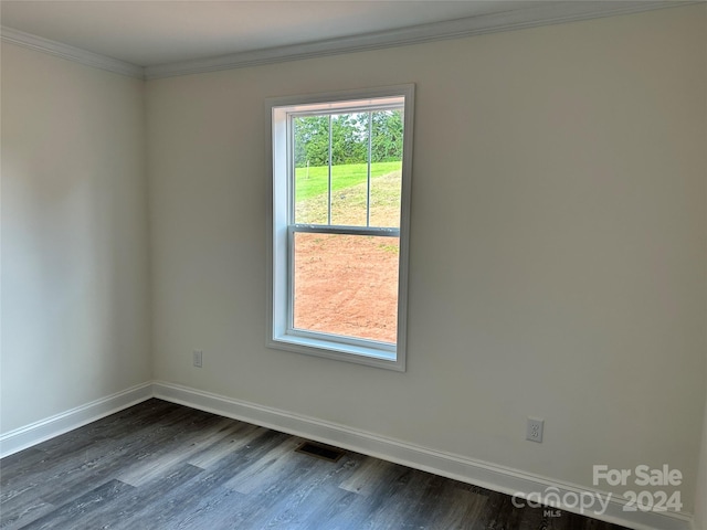 empty room with dark hardwood / wood-style flooring and ornamental molding