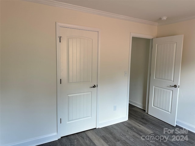 unfurnished bedroom with dark hardwood / wood-style floors and crown molding