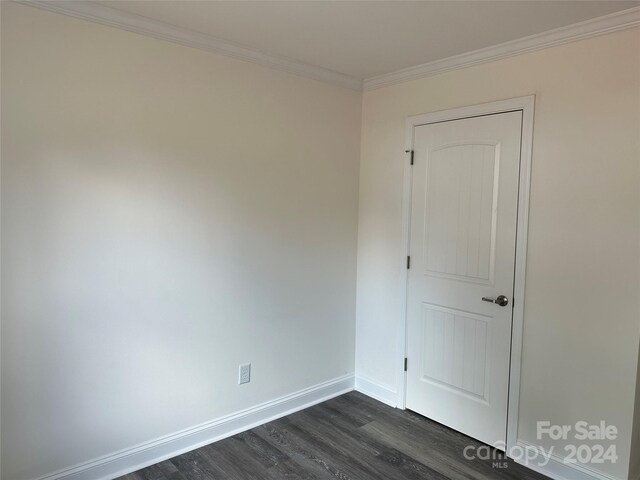 unfurnished room with dark hardwood / wood-style floors and ornamental molding