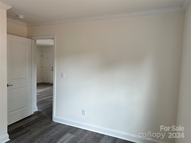 empty room featuring dark hardwood / wood-style flooring and crown molding