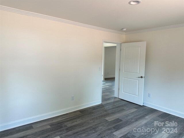 spare room featuring dark hardwood / wood-style floors and ornamental molding