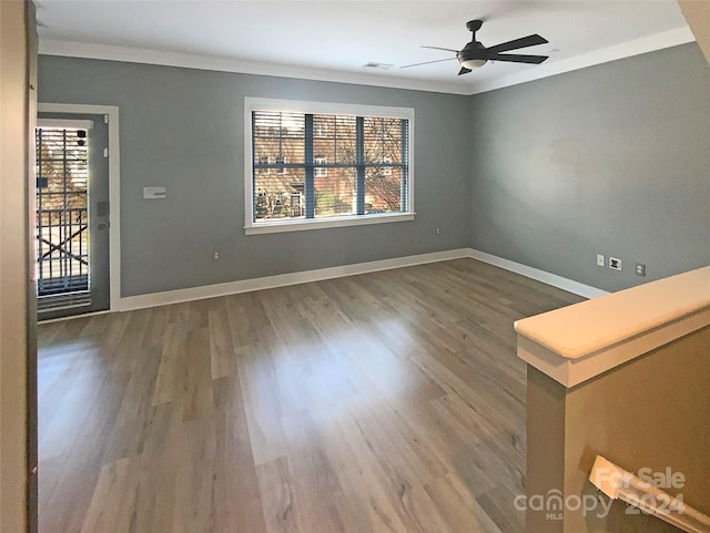 spare room with wood-type flooring, ceiling fan, and crown molding