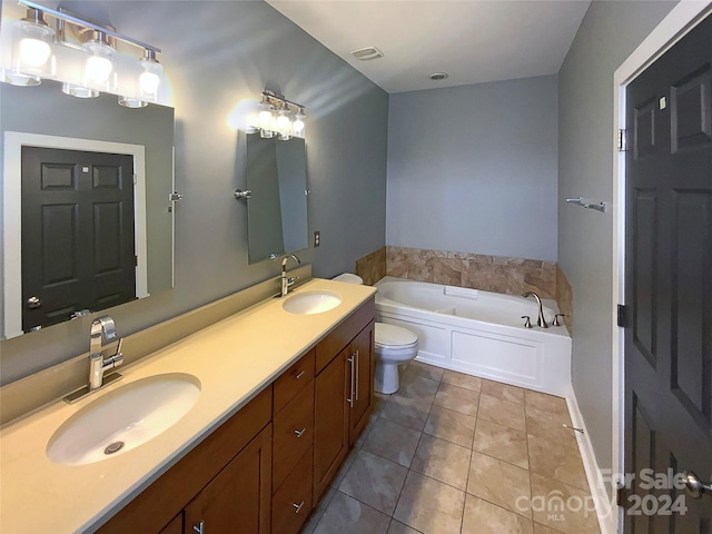 bathroom featuring tile patterned floors, vanity, toilet, and a bathing tub