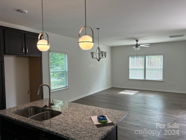 kitchen featuring decorative light fixtures, an island with sink, a wealth of natural light, and sink