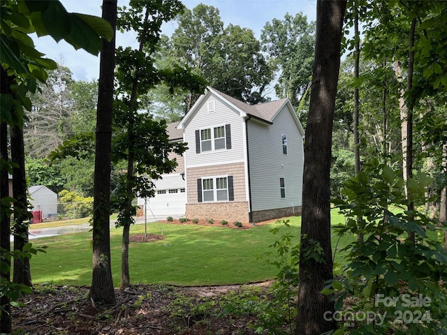 view of home's exterior featuring a lawn and a garage