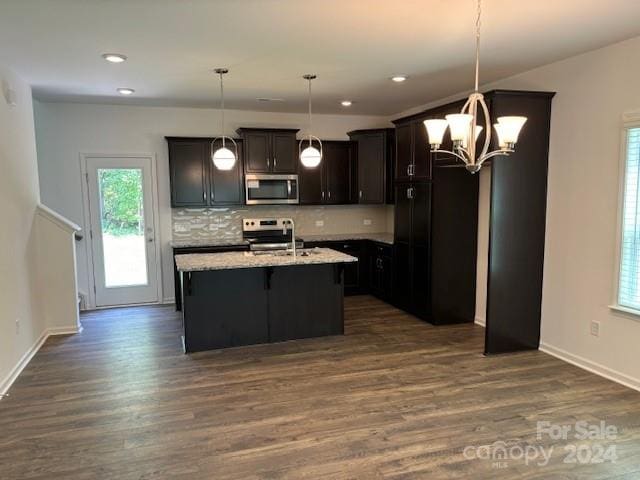 kitchen featuring a chandelier, decorative backsplash, hanging light fixtures, and appliances with stainless steel finishes