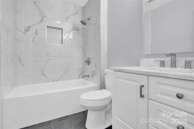 full bathroom with tiled shower / bath, tile flooring, toilet, and vanity