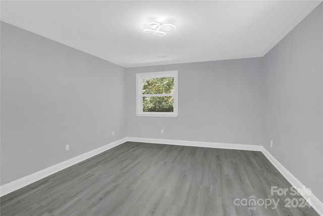 empty room featuring hardwood / wood-style flooring and crown molding