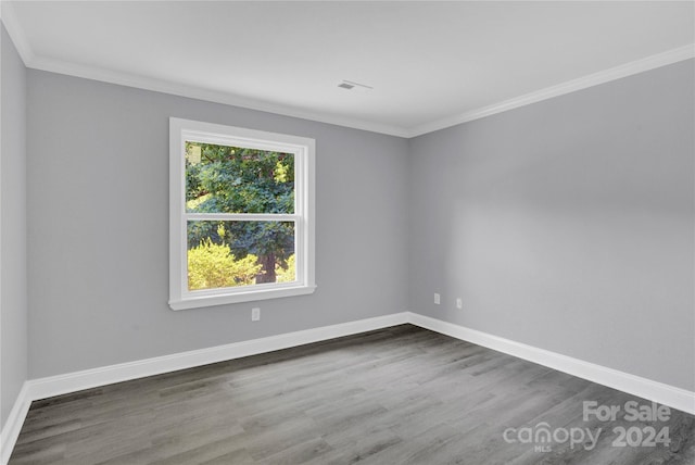 empty room featuring crown molding and dark hardwood / wood-style floors