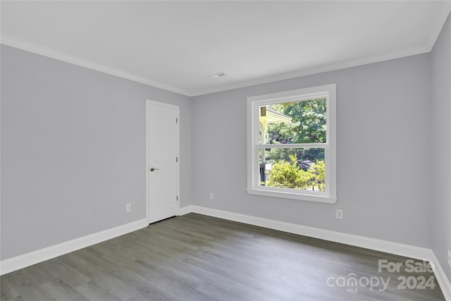 empty room featuring dark hardwood / wood-style floors and ornamental molding