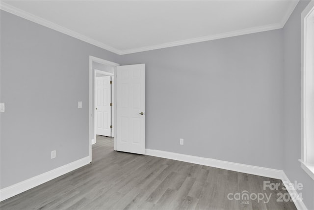 unfurnished room featuring light wood-type flooring and ornamental molding