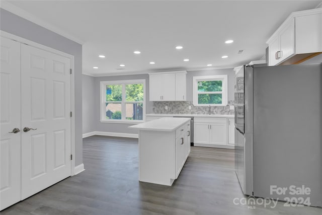 kitchen with white cabinetry, stainless steel appliances, tasteful backsplash, a wealth of natural light, and a center island