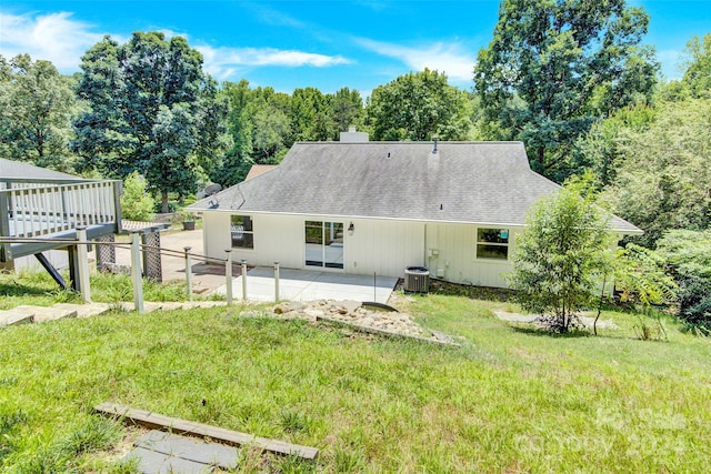 back of property with a patio area, a lawn, and central AC