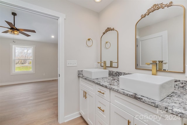 bathroom with wood-type flooring, vanity, and ceiling fan