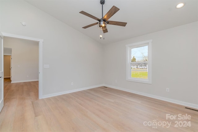 unfurnished room with ceiling fan, lofted ceiling, and light wood-type flooring