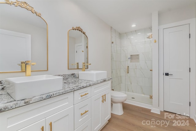 bathroom featuring vanity, hardwood / wood-style flooring, toilet, and a shower with shower door