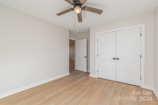 unfurnished bedroom featuring ceiling fan, a closet, and light wood-type flooring