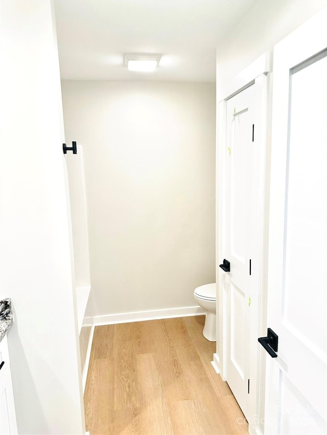 bathroom featuring hardwood / wood-style flooring, toilet, and a tub