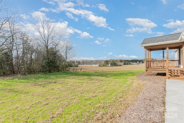 view of yard with a rural view and a deck