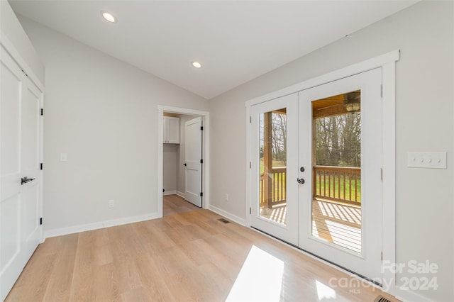 doorway featuring light hardwood / wood-style floors, lofted ceiling, and french doors