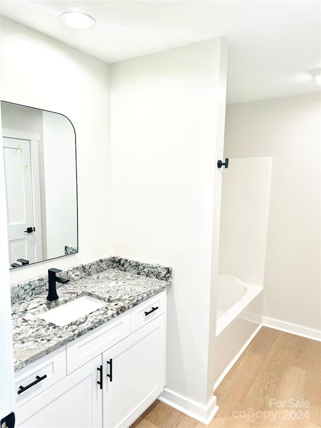 bathroom featuring bathtub / shower combination, vanity, and hardwood / wood-style flooring