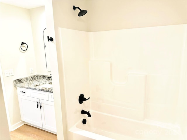 bathroom featuring hardwood / wood-style floors, vanity, and shower / bathtub combination