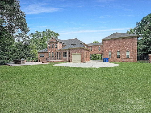 rear view of house with a fire pit, a garage, a patio area, and a yard