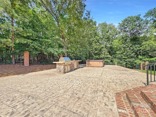 view of patio featuring area for grilling, an outdoor kitchen, and a hot tub